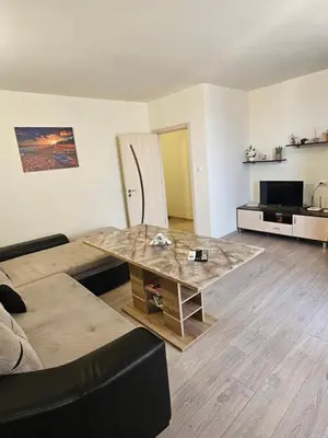 a living room with a couch and a table at Апартамент ИВАНОВИ Сарафово in Burgas City