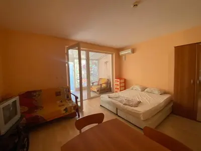 a bedroom with a bed and a table and a tv at Stella Polaris 1 Apartments in Sunny Beach