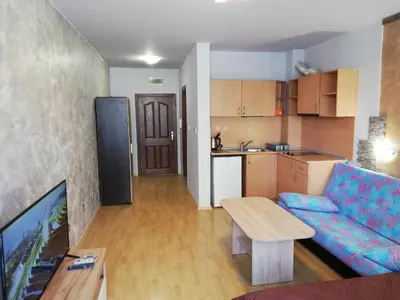 a living room with a couch and a table and a kitchen at Lovely Studio in a Complex with a Pool by Flat Mаnаger in Sveti Vlas