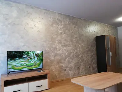 a living room with a flat screen tv on a wall at Lovely Studio in a Complex with a Pool by Flat Mаnаger in Sveti Vlas