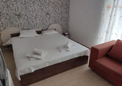 a bedroom with a bed and a red couch at Ideal three bed apartment for families closed to the Beach in Sunny Beach