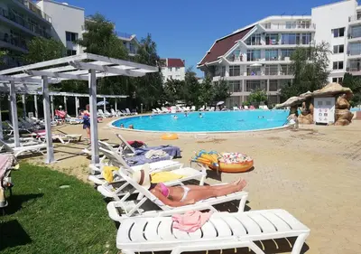 a group of people laying on lounge chairs at a pool at Ideal three bed apartment for families closed to the Beach in Sunny Beach