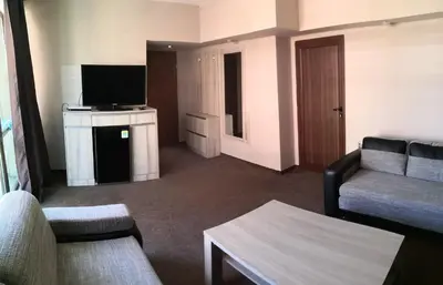 a living room with a couch and a television at euroHOTEL Primorsko in Primorsko