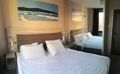 a bedroom with two beds with white sheets and pillows at euroHOTEL Primorsko in Primorsko
