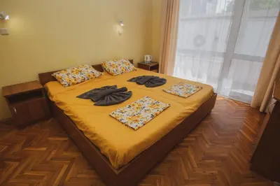 a bedroom with a bed with yellow sheets and pillows at Rooms in New Town Nessebar by Flat Mаnаger in Nesebar