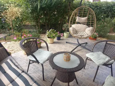 a patio with chairs and a table and a rattan chair at вила ФЛОРА in Chernomorets