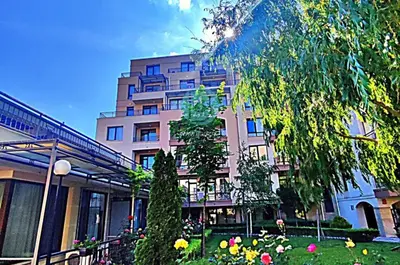 a large pink building with flowers in front of it at Sorrento Sole Mare - Apartments by the beach in Sveti Vlas