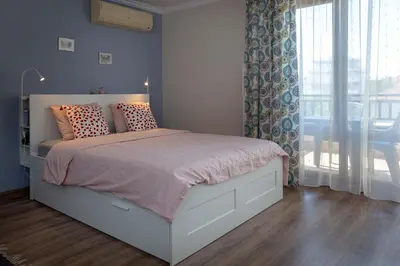 a bedroom with a white bed with pillows and a window at Studio Maré Chernomorets in Chernomorets