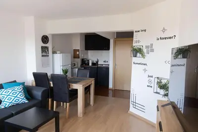 a living room with a table and a kitchen at Lovely 1BD Flat near the Sea Garden by Flat Mаnаger in Burgas City