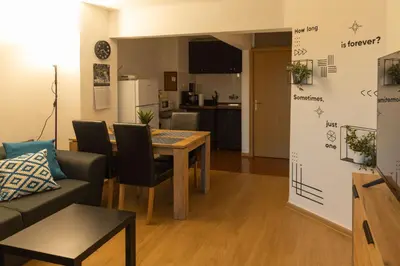 a living room with a table and a kitchen at Lovely 1BD Flat near the Sea Garden by Flat Mаnаger in Burgas City
