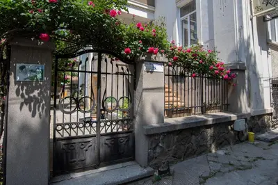 a wrought iron gate with pink flowers on a building at Art Studios Elsor in Burgas City