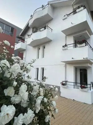 a bunch of white roses in front of a building at Къща за гости CANAVAN'S in Ravda