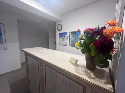 a vase of flowers on a counter in a room at Къща за гости CANAVAN'S in Ravda