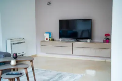 a living room with a tv on a white wall at Black Sea Top Centre Apartments by Flat manаger in Varna City