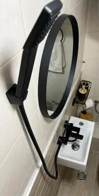 a black mirror hanging on a wall next to a sink at A&K Guest Studio in Varna City