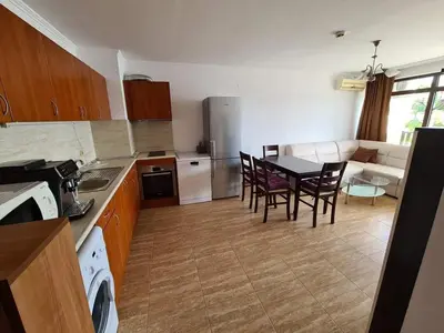 a kitchen and dining room with a table and chairs at Апартамент с фронтална гледка море in Sveti Vlas