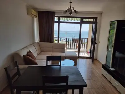 a living room with a couch and a table at Апартамент с фронтална гледка море in Sveti Vlas