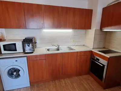 a kitchen with a sink and a washing machine at Апартамент с фронтална гледка море in Sveti Vlas