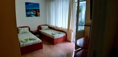 a small room with two beds and a window at Laguna in Kiten