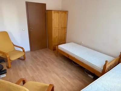 a bedroom with a bed and a chair and a cabinet at 2-комнатные апартаменты у моря 10 бассейнов Crown Fort Noks in Sveti Vlas