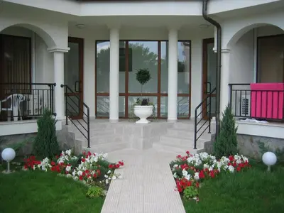 a porch of a building with a vase and flowers at Chateau Del Mar Holiday Apartments in Sunny Beach
