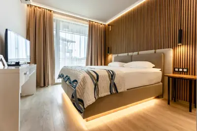 a bedroom with a large bed and a television at Galeon Residence & SPA in Sunny Beach