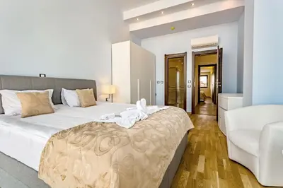 a white bedroom with a large bed and a couch at Galeon Residence & SPA in Sunny Beach