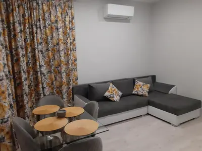a living room with a couch and two tables at Sea & chill suite in Burgas City