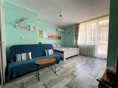 a living room with a blue couch and a table at Bright 1BD Apartment with Nice Terrace by Flat Mаnаger in Burgas City