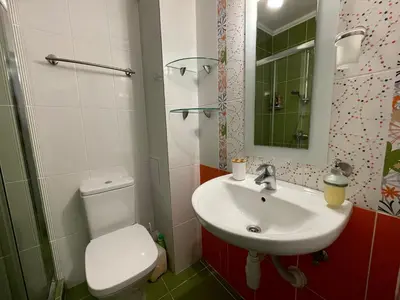 a bathroom with a sink and a toilet and a mirror at Bright 1BD Apartment with Nice Terrace by Flat Mаnаger in Burgas City