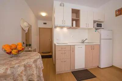 a kitchen with a bowl of fruit on a table at Sunny View Central Holiday Apartments in Sunny Beach