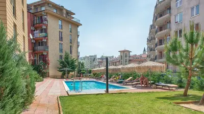 a swimming pool in the middle of a courtyard with buildings at Sunny View Central Holiday Apartments in Sunny Beach