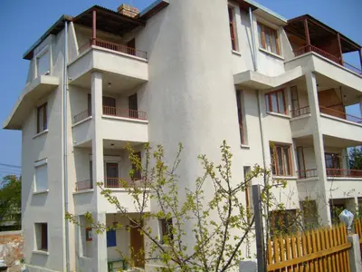a white building with red balconies on it at Сотирови, самостоятелни стаи in Chernomorets