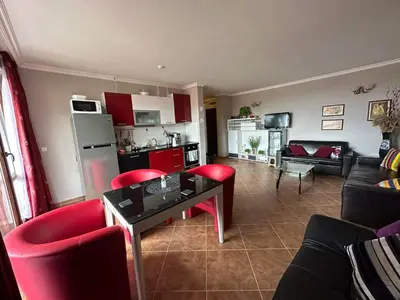 a living room with a table and red chairs at Sirena in Sveti Vlas