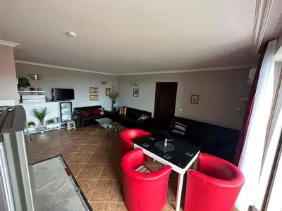 a living room with red chairs and a table at Sirena in Sveti Vlas