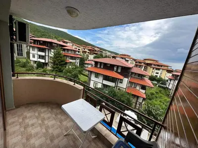 a balcony with a white chair and some buildings at Sirena in Sveti Vlas