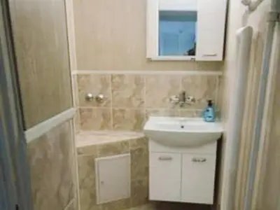 a bathroom with a sink and a toilet and a mirror at Апартамент Арена Бургас in Burgas City