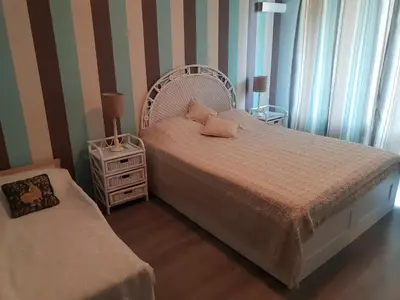 a bedroom with a white bed and a night stand at Lilly apartment Pomorie in Pomorie