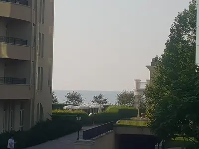 a person walking down a street next to a building at Lilly apartment Pomorie in Pomorie