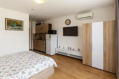 a bedroom with a bed and a refrigerator at Apolon 8 Relax Studio with Pools in Sunny Beach