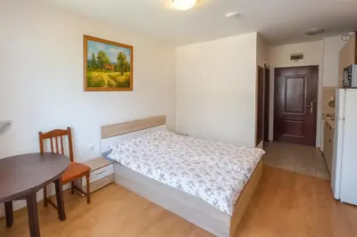 a small bedroom with a bed and a table at Apolon 8 Relax Studio with Pools in Sunny Beach