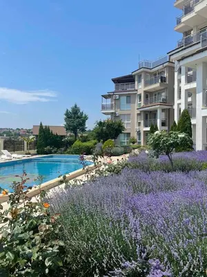 a garden with purple flowers in front of a building at Fortuna Cape-Byala SP apartments in Byala