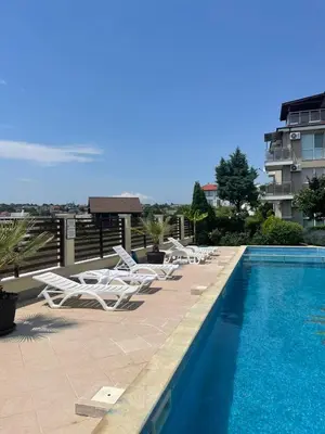 a group of lounge chairs and a swimming pool at Fortuna Cape-Byala SP apartments in Byala