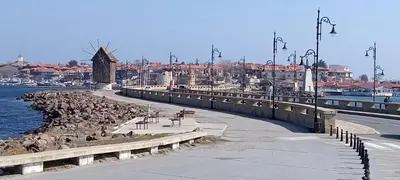 a group of birds sitting on a sidewalk next to the water at Глобал вил in Sunny Beach
