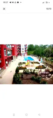 a view of a building with a pool and a playground at Глобал вил in Sunny Beach