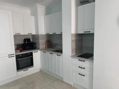 a white kitchen with white cabinets and appliances at Fenix Apart Complex in Sveti Vlas