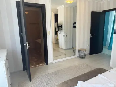 a bathroom with a glass door and a mirror at Fenix Apart Complex in Sveti Vlas