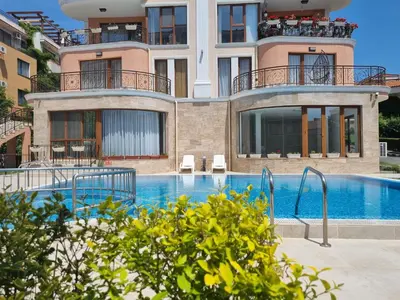 a building with a swimming pool in front of a building at Fenix Apart Complex in Sveti Vlas