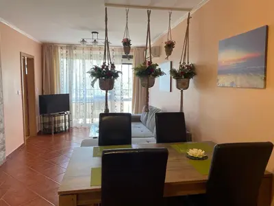 a living room with a dining room table with chairs at VIP Style private apartments in Elenite