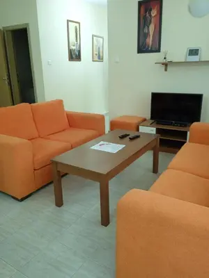 a living room with orange furniture and a coffee table at Big comfortable apartment with 2 bedrooms Pollo Resort Sunny Beach in Sunny Beach